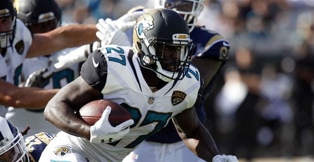 Leonard Fournette running with a football during a game.